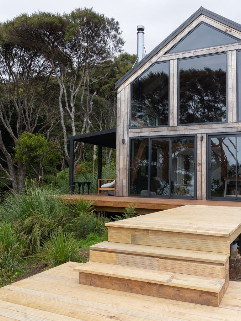 Glazed gable ends of an architecturally designed barn home using mortise and tenon joinery in native New Zealand bush