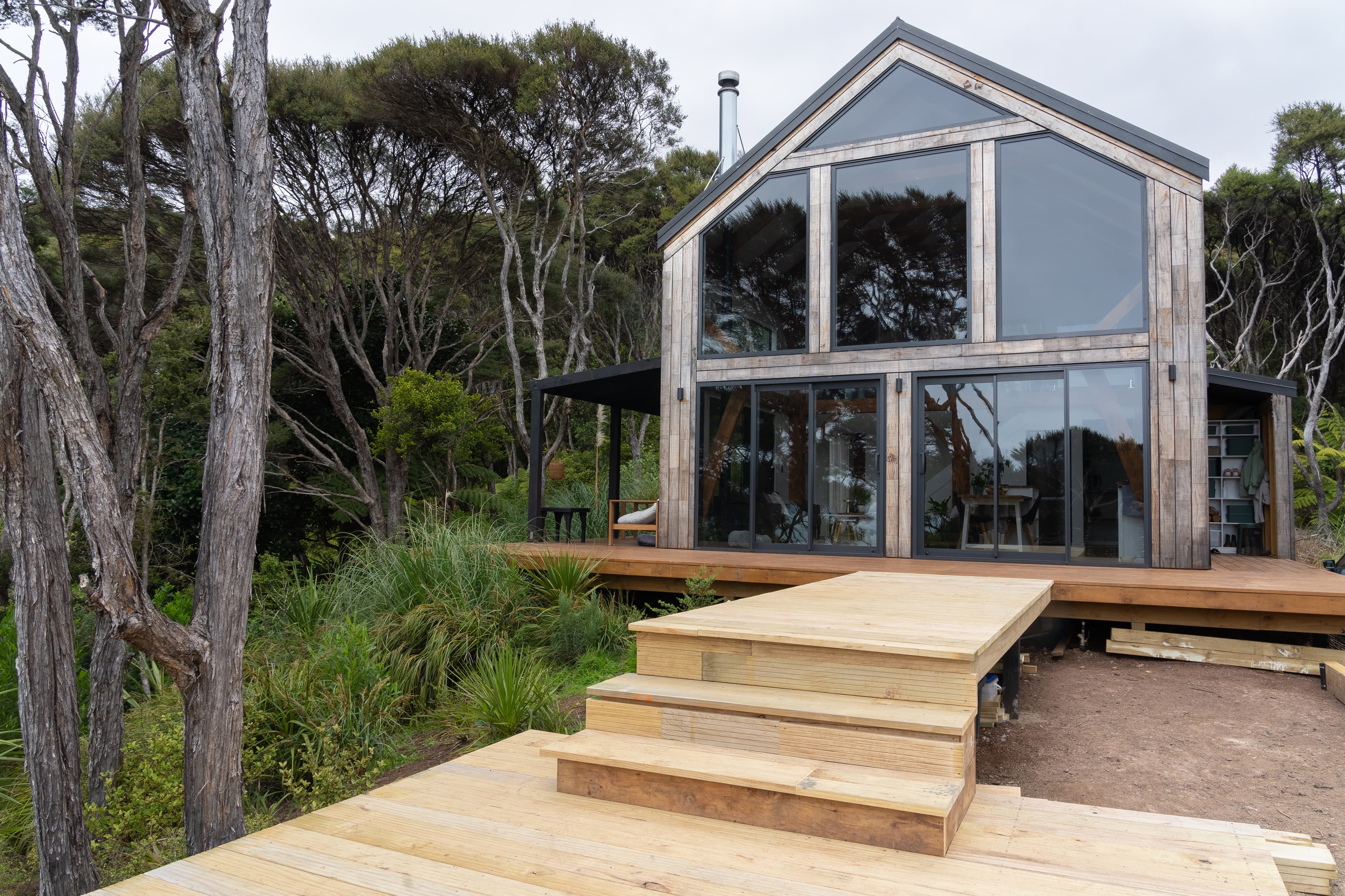 Glazed gable ends of an architecturally designed barn home using mortise and tenon joinery in native New Zealand bush