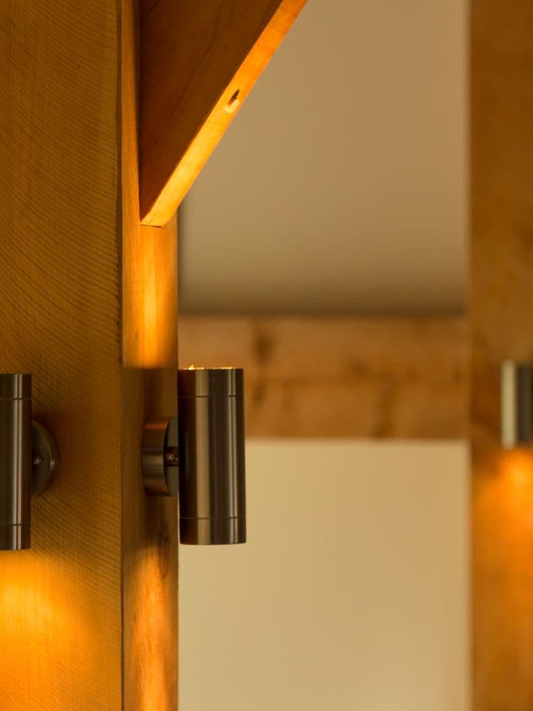 Highlight the quality timber and craftsmanship in a timber home with the use of stylish interior lighting
