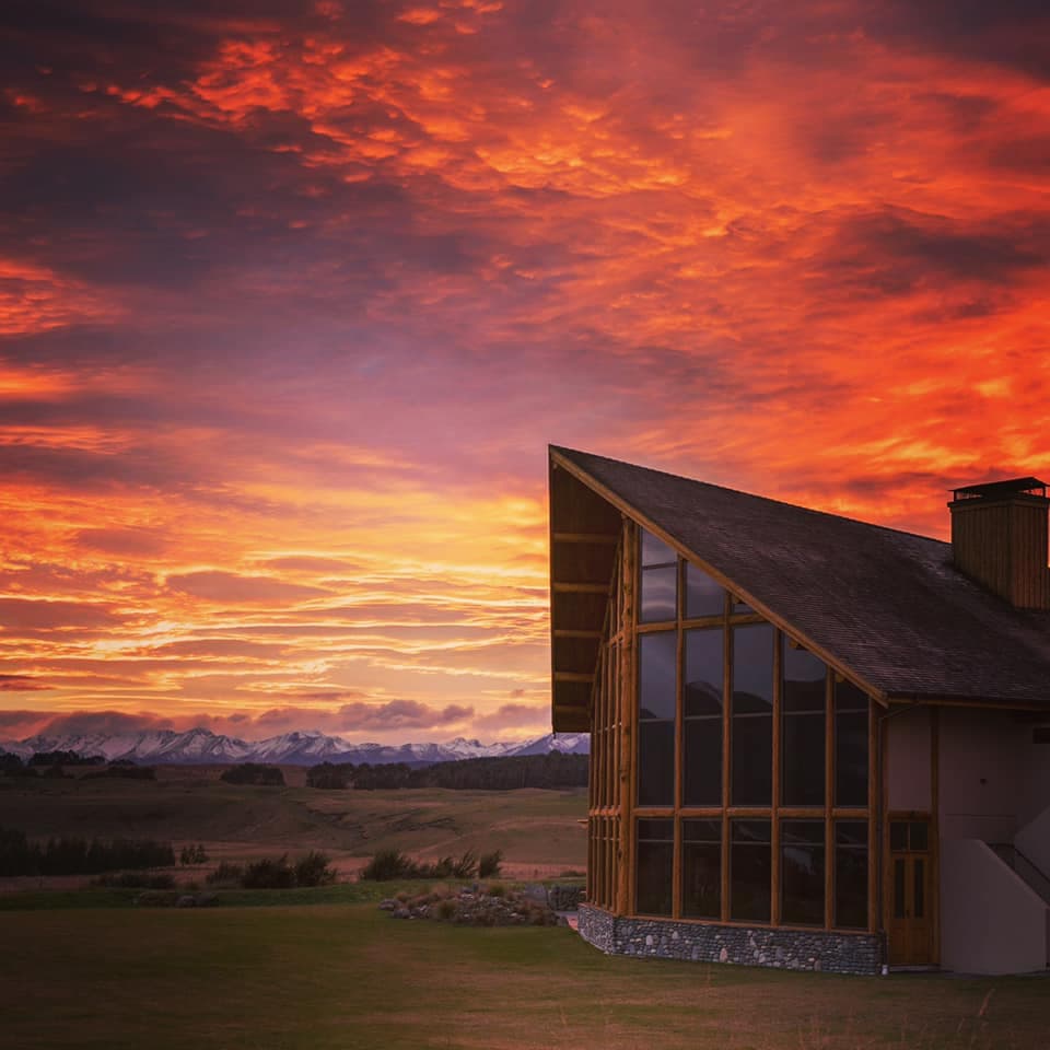 Alpine lodge built with Douglas-fir timber using traditional timber frame building methods in a captivating red sky sunset